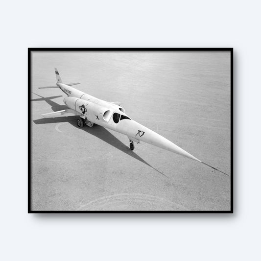 A black and white image captures the sleek, experimental X-3 aircraft, characterized by its long, pointed nose and short wings, parked on a flat lakebed runway. Adorned with military insignia and the designation "X3," its shadow is clearly visible on the ground. This stunning print from 'X Planes' is perfect for aviation wall art or aerospace engineering decor.
