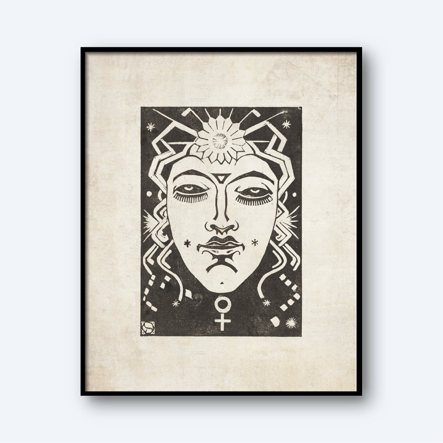 The framed black and white artwork titled "Venus - Planet Masks by Henri van der Stok" depicts a stylized face with closed eyes and intricate geometric patterns. A sun-like shape adorns the forehead, while the symbol for Venus sits below the chin. This exquisite piece of astrology wall art is set against a textured, neutral background.