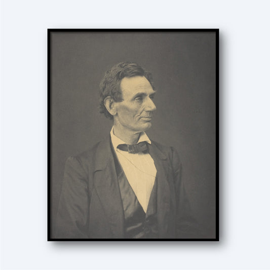 The "Abraham Lincoln by Alexander Hesler" photograph features a black-and-white portrait of a man with short, dark hair, dressed in a suit with a bow tie. He faces slightly to the left with a thoughtful expression. The portrait, distinguished by its gravitas akin to an Abraham Lincoln portrayal, is framed in black and set against a neutral background.