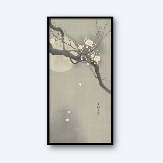 The framed vertical artwork titled "Plum blossom and full moon by Ohara Koson" features a serene scene with blooming white plum blossoms on a branch set against a misty, muted gray background. A faint full moon enhances the tranquil atmosphere in the backdrop, and Japanese calligraphy is present near the bottom of the image.