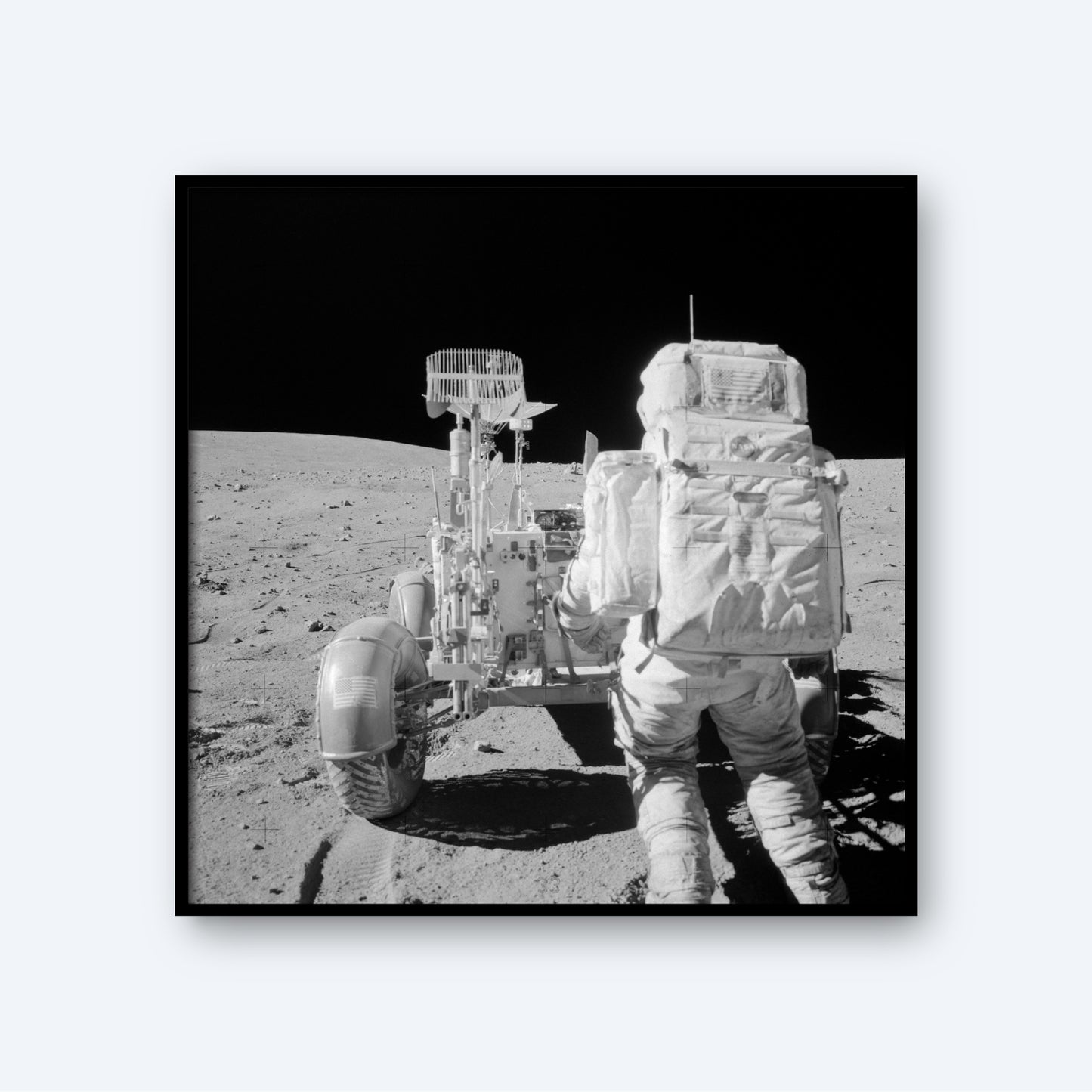 The product titled "NASA Apollo 16 Astronaut and Lunar Rover" features a black and white photograph of an astronaut from the Apollo 16 mission, clad in a spacesuit, standing on the moon's surface beside a lunar rover. The desolate landscape stretches out to the horizon under a dark, starless sky. In this historic moment of space exploration, the astronaut seems to be inspecting the rover.