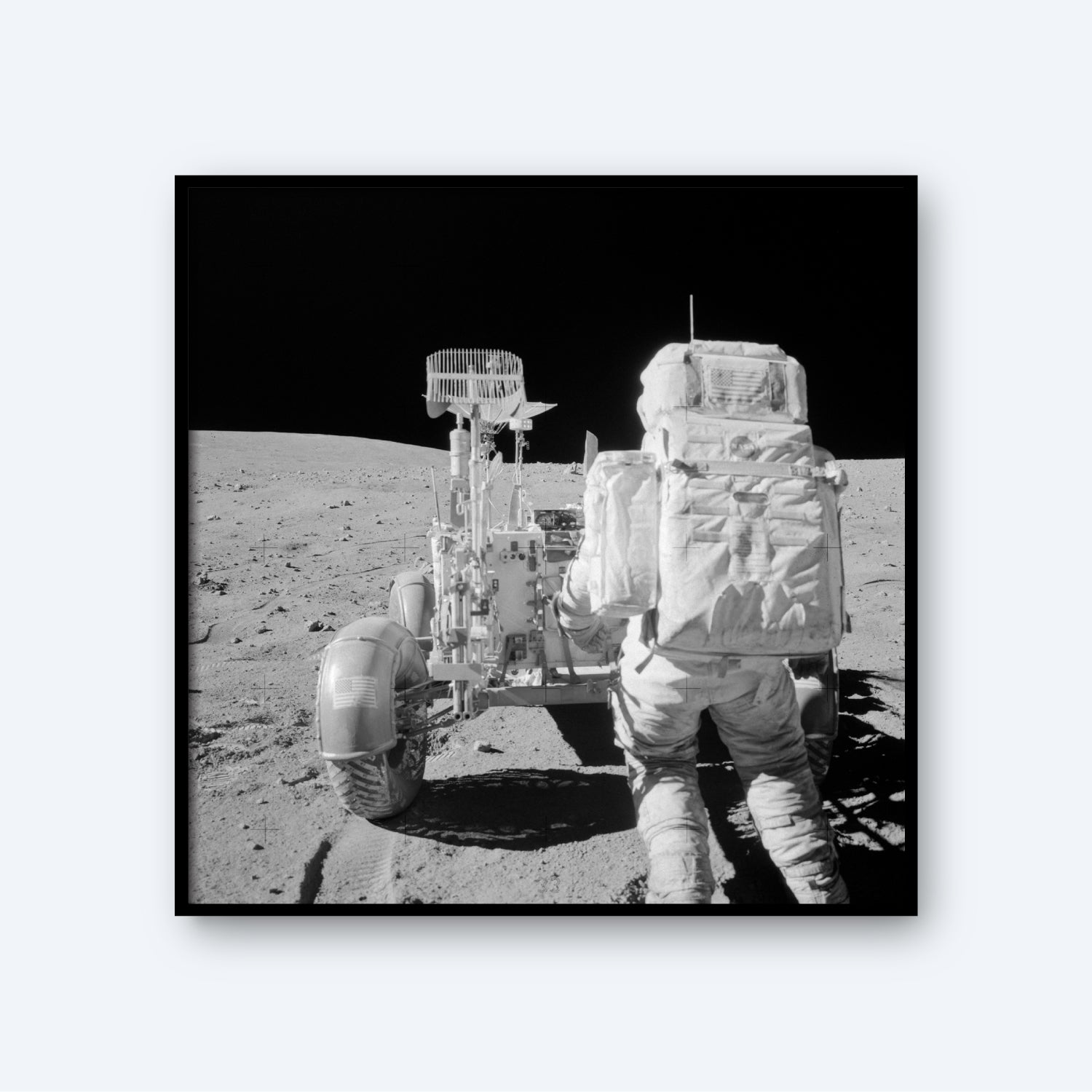 The product titled "NASA Apollo 16 Astronaut and Lunar Rover" features a black and white photograph of an astronaut from the Apollo 16 mission, clad in a spacesuit, standing on the moon's surface beside a lunar rover. The desolate landscape stretches out to the horizon under a dark, starless sky. In this historic moment of space exploration, the astronaut seems to be inspecting the rover.
