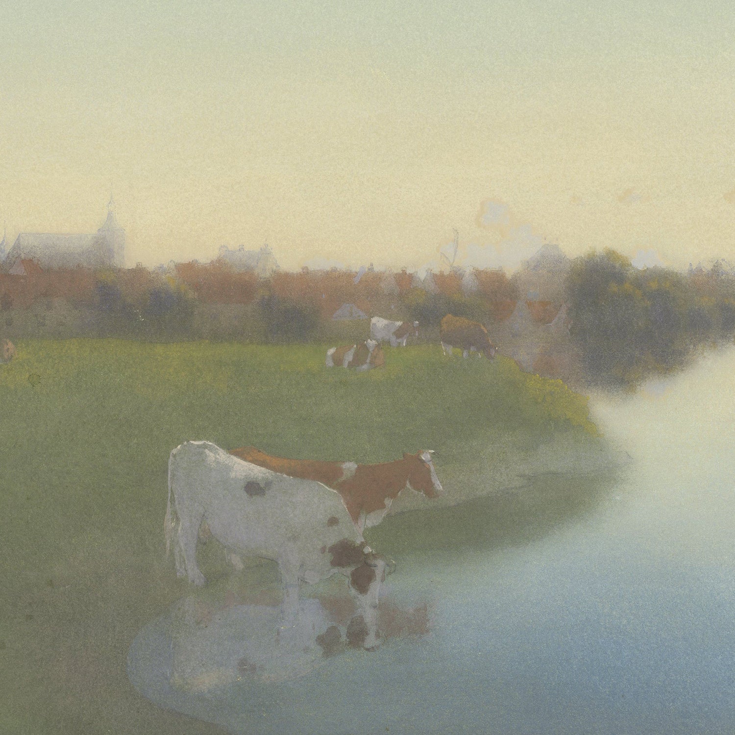 A serene pastoral scene featuring cows grazing near a calm riverbank. The landscape is veiled in soft, misty light, with a village visible in the distance under a pale, warm sky. The water reflects the subdued colors of the peaceful surroundings, characteristic of Jan Voerman's Dutch countryside art titled "Bank Of The River Ijssel Near Hattem.