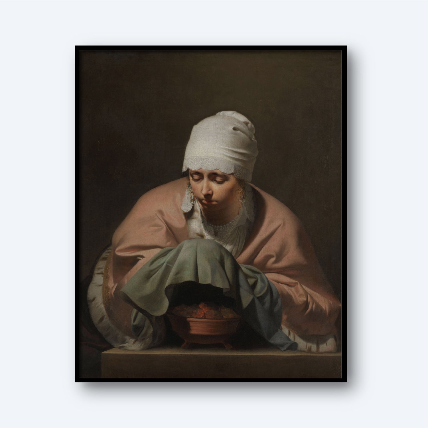 A print titled "Young Woman Warming her Hands over a Brazier" by Caesar van Everdingen features a woman with a white headscarf and pink shawl leaning over a pot. She has a contemplative expression and holds a green cloth, while the dark background emphasizes her and the pot. This Dutch Golden Age artwork comes framed in black.