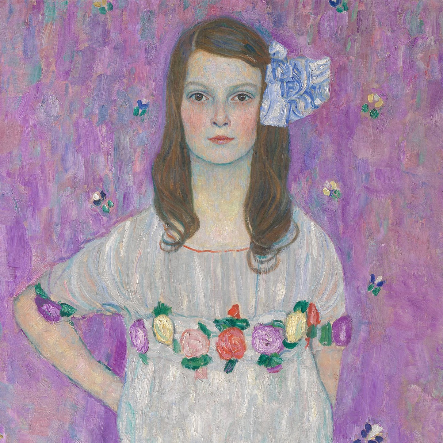 Against a purple, textured background stands a young girl with long brown hair, adorned with a large white flower. She wears a white dress featuring colorful floral patterns around the waist and sleeves. The impressionistic style of this print evokes elements of early 20th-century portraiture and is reminiscent of Gustav Klimt's celebrated work, "Mäda Primavesi." This exquisite piece is named "Mäda Primavesi by Gustav Klimt Print.