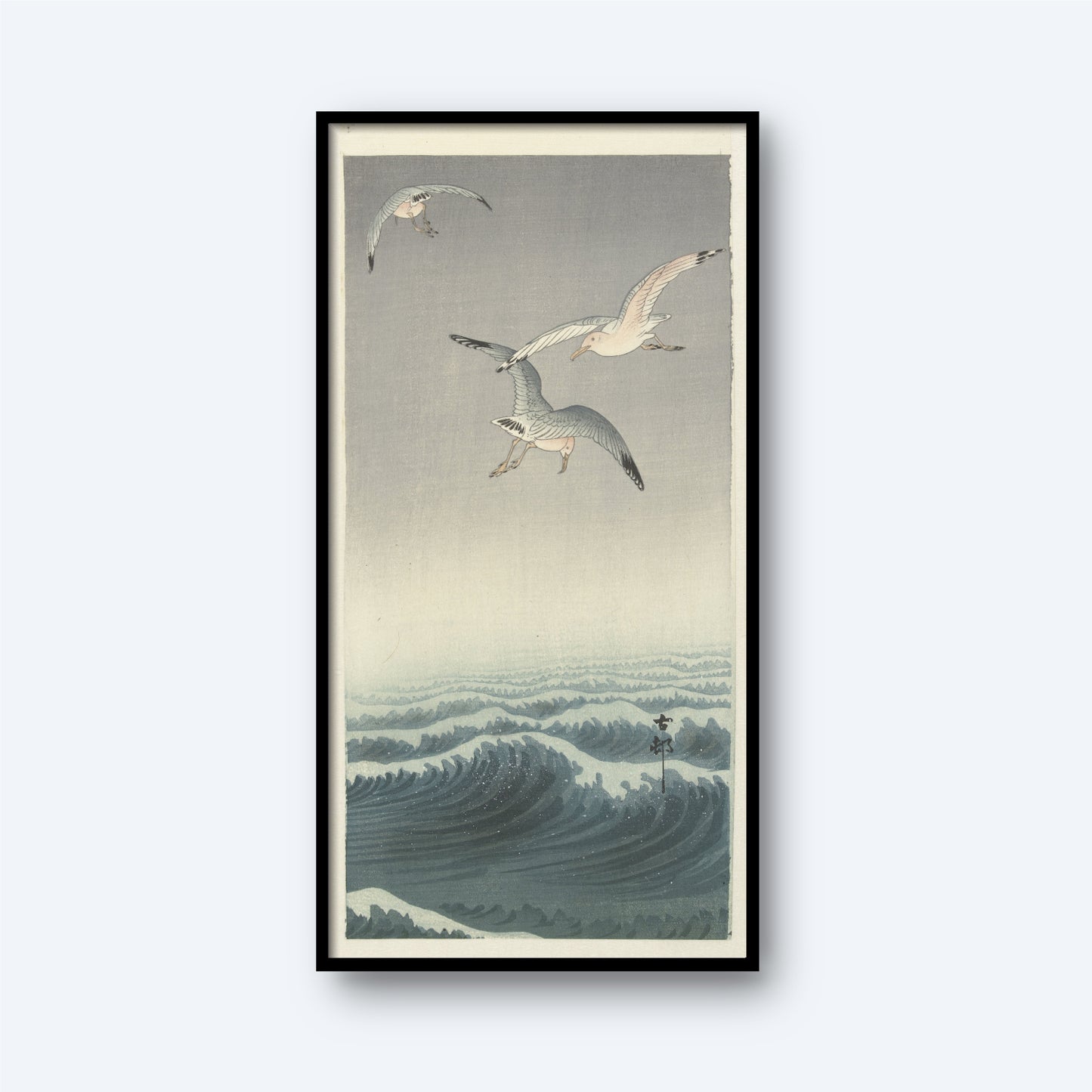 A framed "Three Seagulls by Ohara Koson | Vintage Japanese Woodblock Print" features three seagulls soaring above a turbulent ocean with rolling waves. The scene is illustrated in a traditional Japanese ukiyo-e style, reminiscent of Ohara Koson's work, with soft hues of blue and gray dominating the composition.