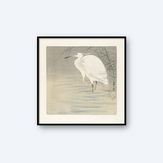 The Little Egret by Ohara Koson, a vintage Japanese print, features a framed artwork of a white egret standing in shallow water with reeds in the background. The scene is reminiscent of Koson's woodblock prints, rendered in a minimalist and monochromatic style with subtle gray and white tones.